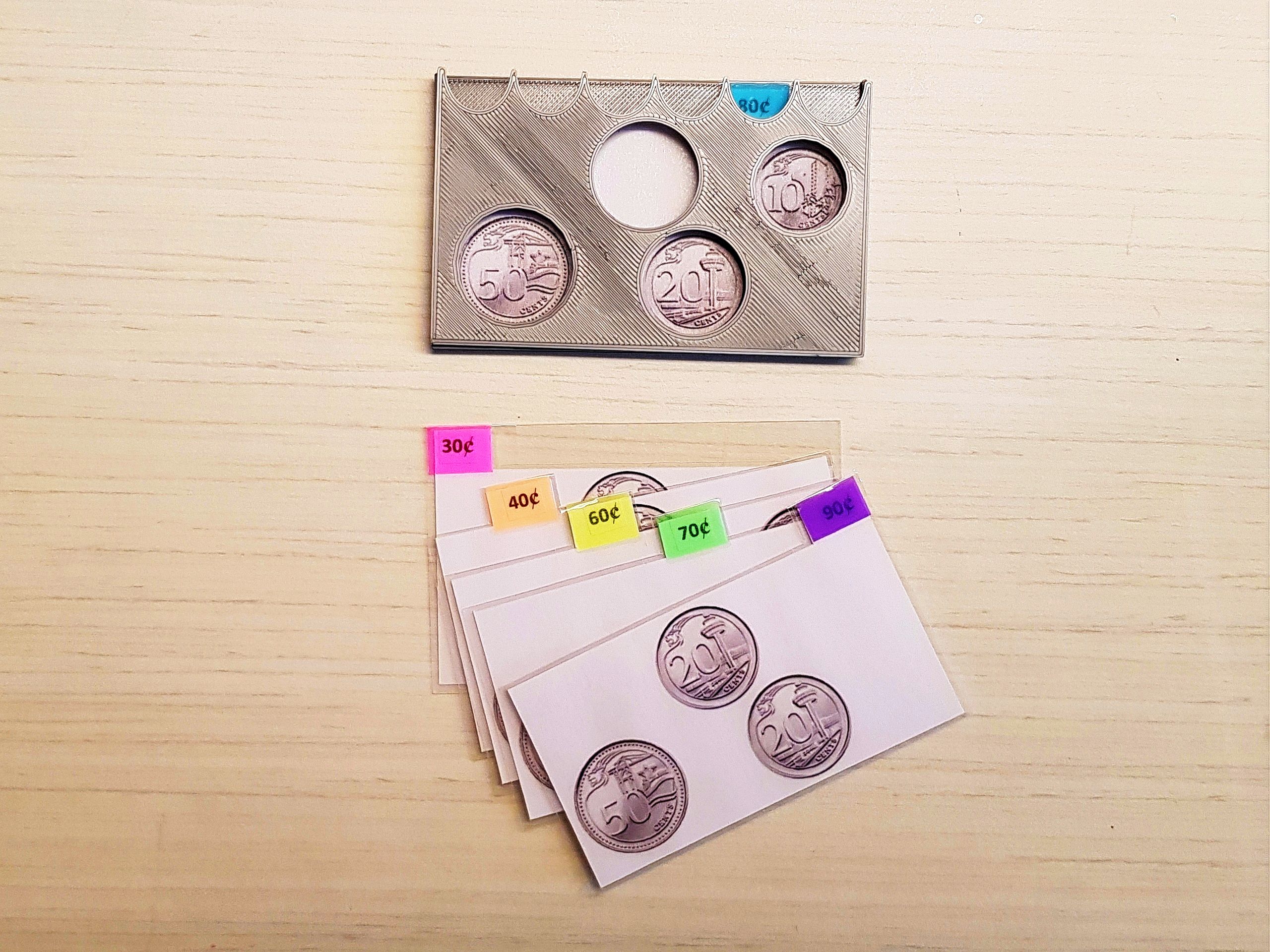 Version 2 of the 3D-printed coin card holder prototype with laminated cards of various combinations of printed images of 10, 20, and 50 cents.